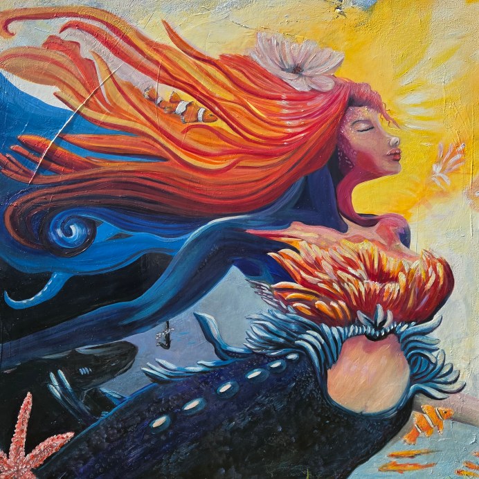 A mermaid painting with flowing flame-colored hair